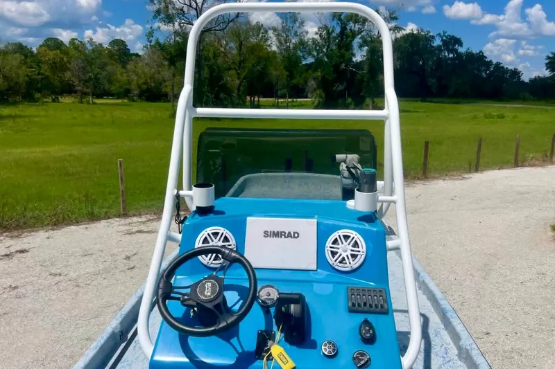 Slide: The Image of 2022 Flats Cat 21' boat dashboard with steering wheel and Simrad electronics. - 6