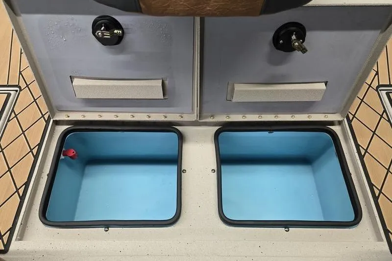 Slide: The Image of Storage compartments of 2026 Avid 18 Vertex boat, featuring dual blue interior spaces. - 10