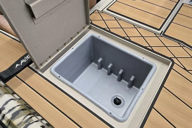 Slide: The Image of Open storage compartment on 2026 Avid 18 Vertex boat with wood-patterned flooring. - 2