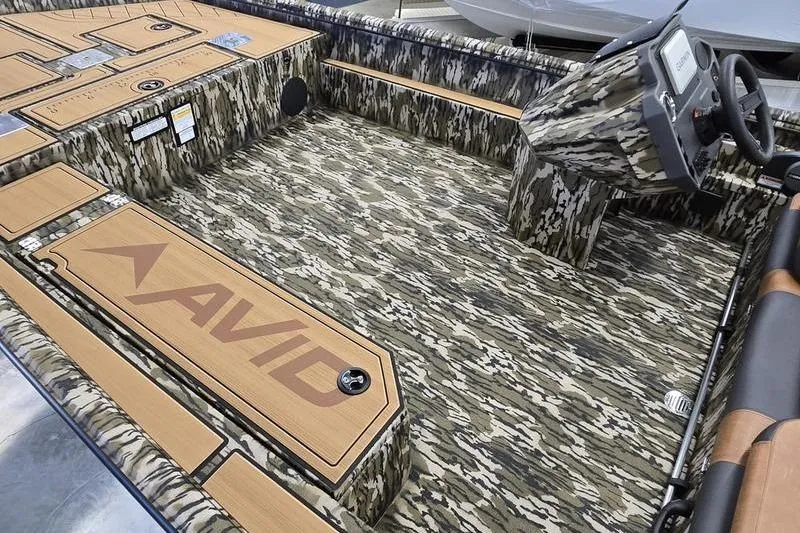 Slide: The Image of 2026 Avid 20 Rogue SC boat interior with camouflage design and steering console. - 13