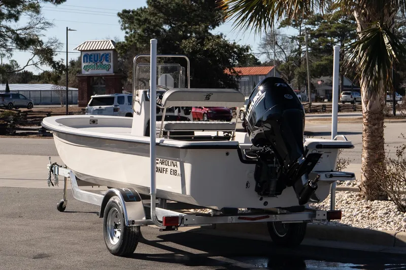 Slide: The Image of 2026 Carolina Skiff E18 JVX CC boat on trailer, parked near Neuse Sport Shop. - 4