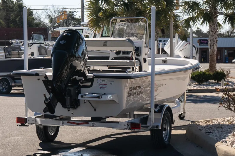 Slide: The Image of 2026 Carolina Skiff E18 JVX CC boat on trailer, parked outdoors. - 6