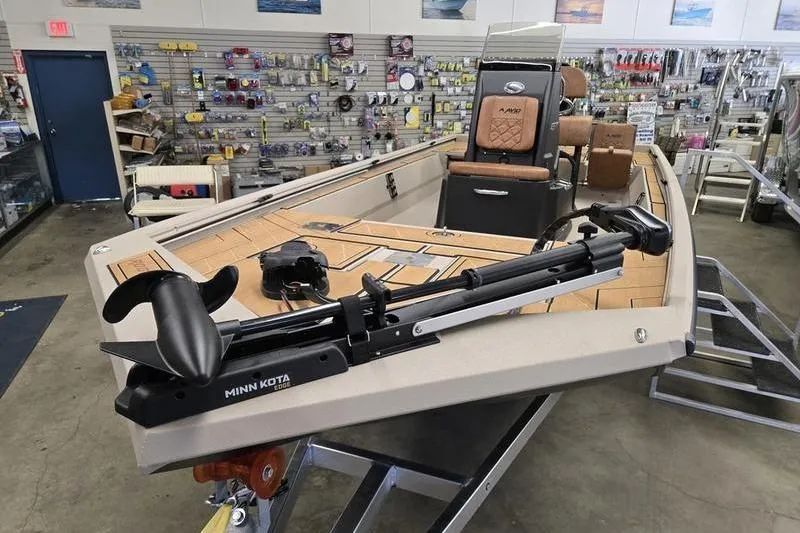 The Image of 2026 Avid 22 Rogue CC boat displayed in a showroom with fishing equipment. - 1