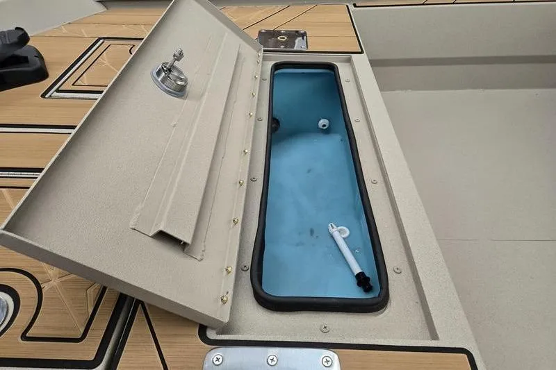 Slide: The Image of Open storage compartment on 2026 Avid 22 Rogue CC boat deck. - 7