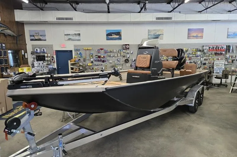 Slide: The Image of 2026 Avid 22 Rogue CC boat displayed in a showroom with fishing gear. - 8