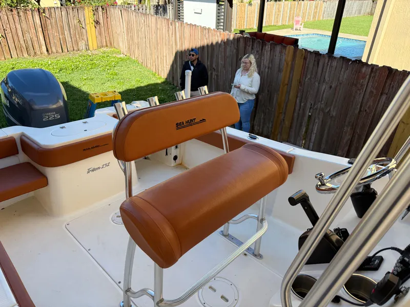 Slide: The Image of 2005 Sea Hunt Triton 232 boat with brown seating, parked in a backyard. - 13