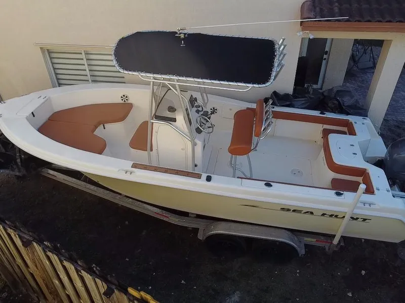 Slide: The Image of 2005 Sea Hunt Triton 232 boat on trailer, featuring orange seating and a black canopy. - 7