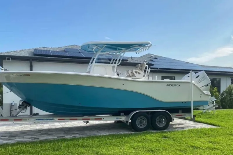 The Image of 2016 Sea Fox 286 Commander boat on trailer, parked near house with solar panels. - 1