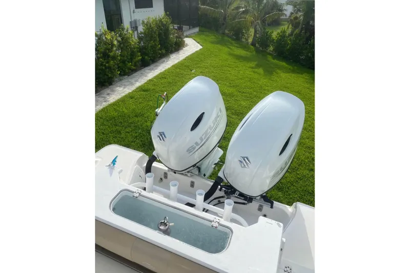 Slide: The Image of 2016 Sea Fox 286 Commander with dual Suzuki outboard motors, parked on grass. - 12