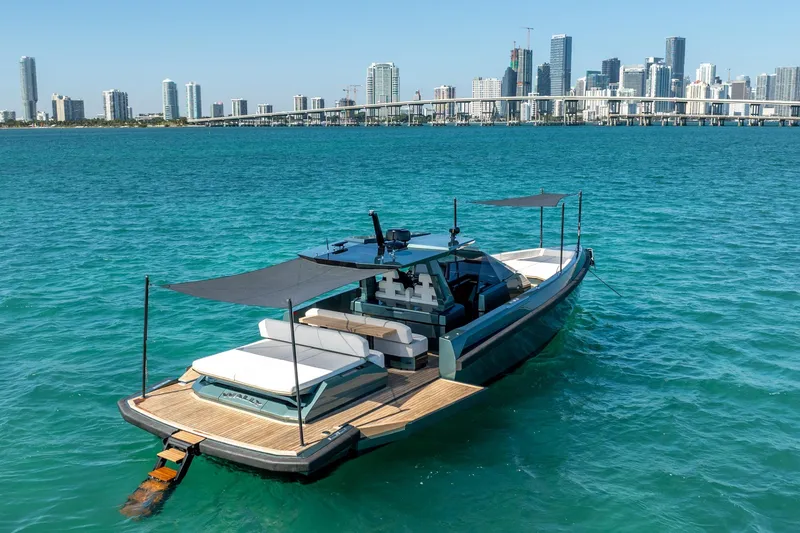 Slide: The Image of 2021 Wally 48 Wally Tender yacht on turquoise water with city skyline backdrop. - 19