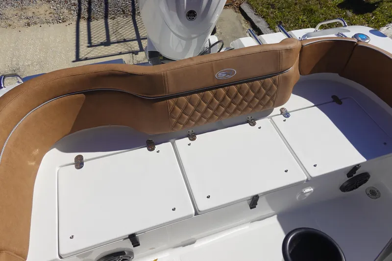 Slide: The Image of 2026 Sea Hunt Ultra 219 boat interior with tan cushioned seating and storage compartments. - 11