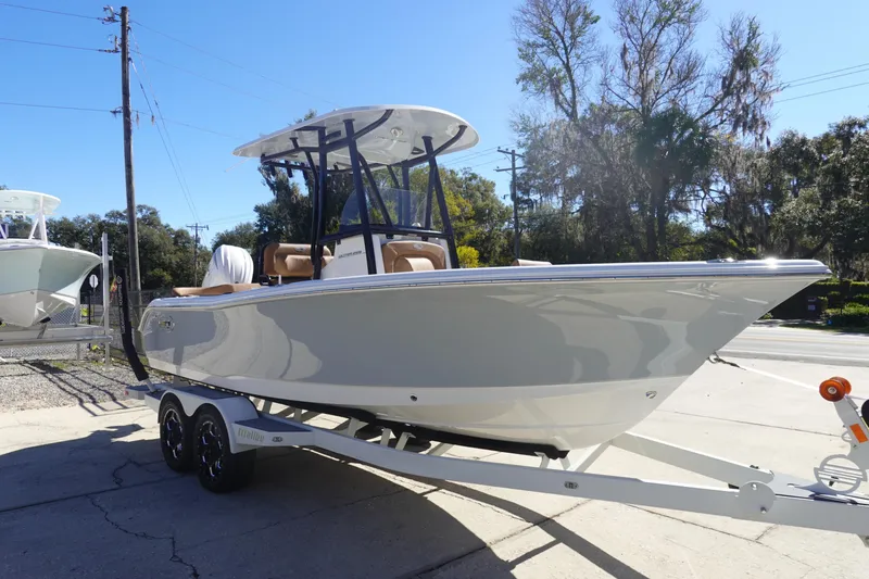 Slide: The Image of 2026 Sea Hunt Ultra 219 boat on trailer, parked outdoors under clear blue sky. - 3