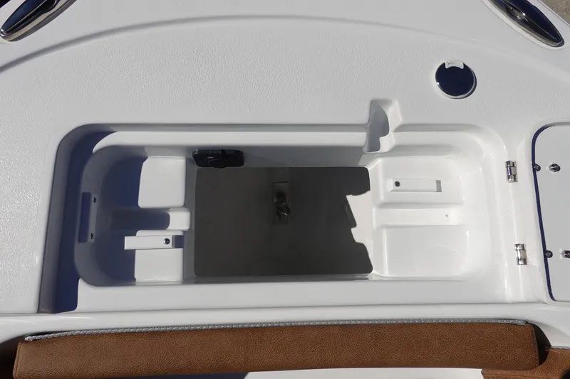 Slide: The Image of 2026 Sea Hunt Ultra 219 boat storage compartment with white interior and brown trim. - 37