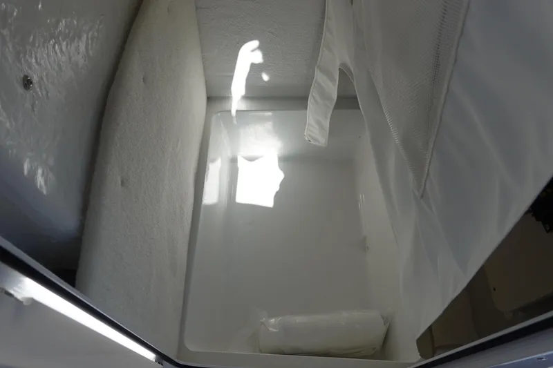 Slide: The Image of Interior storage compartment of 2026 Sea Hunt Ultra 219 boat, featuring white lining. - 38