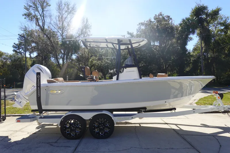Slide: The Image of 2026 Sea Hunt Ultra 219 boat on trailer, parked outdoors in sunny setting. - 4