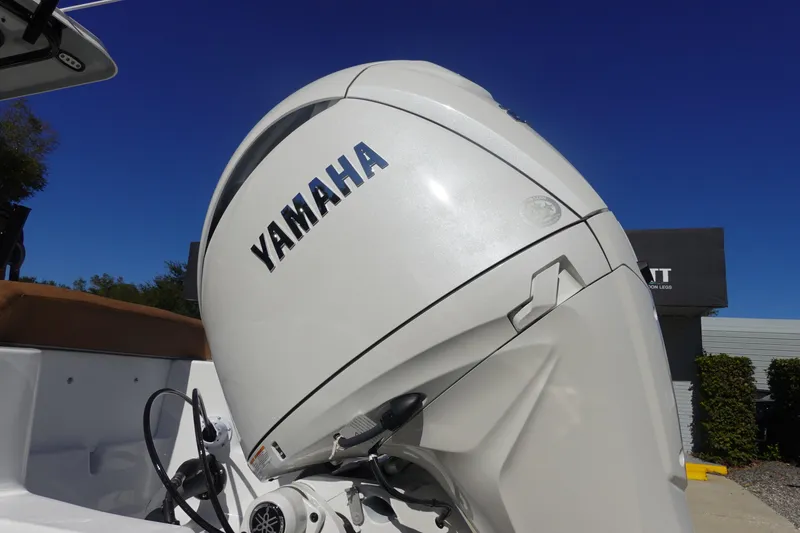 Slide: The Image of 2026 Sea Hunt Ultra 219 with Yamaha outboard motor under clear blue sky. - 6
