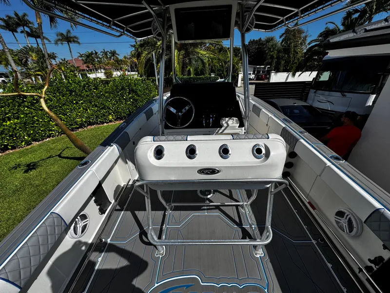 Slide: The Image of 2004 Robalo R 260 boat interior with steering wheel and seating, surrounded by lush greenery. - 12