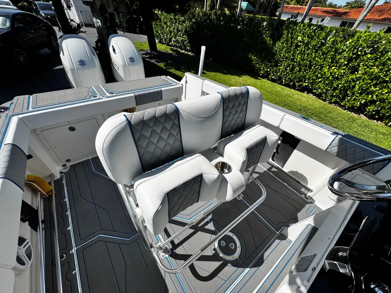 Slide: The Image of 2004 Robalo R 260 boat interior with cushioned seating and dual outboard motors. - 13