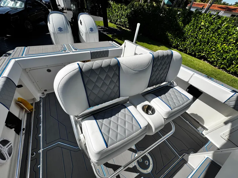 Slide: The Image of 2004 Robalo R 260 boat interior with cushioned seating and dual outboard motors. - 14