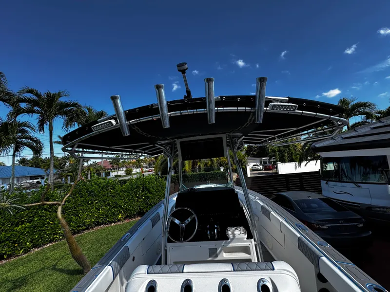 Slide: The Image of 2004 Robalo R 260 boat with T-top and rod holders, parked outdoors. - 15