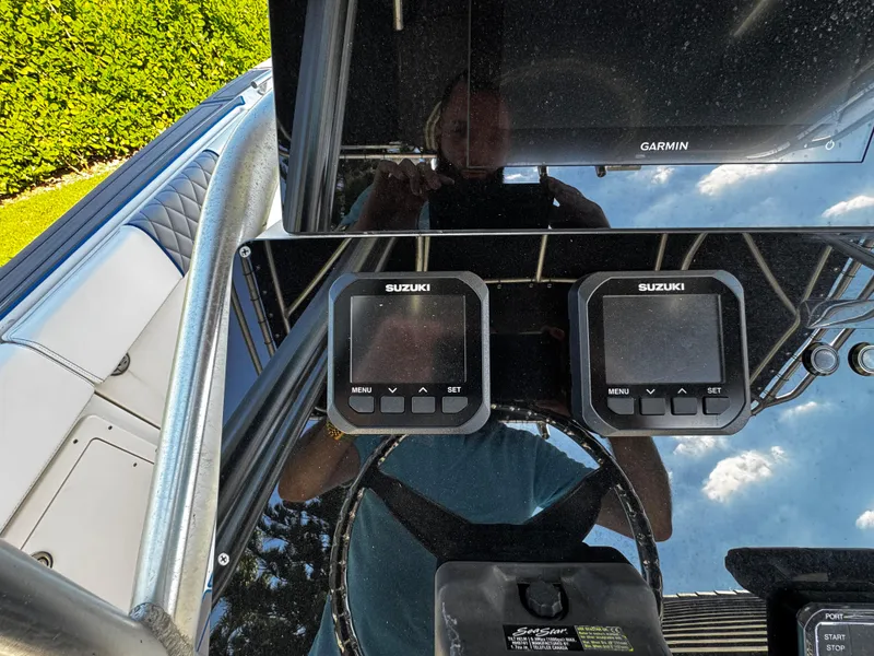 Slide: The Image of 2004 Robalo R 260 boat dashboard with Suzuki displays and Garmin equipment. - 18