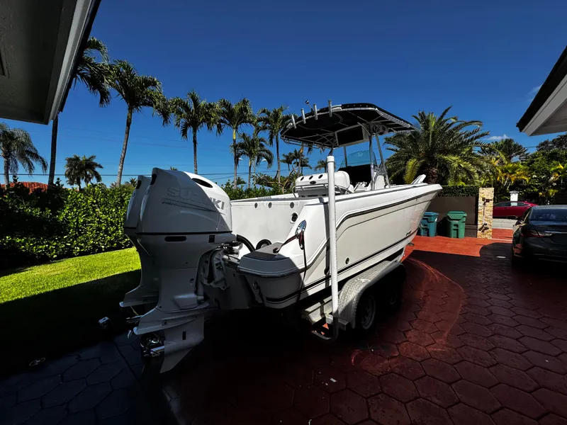 Slide: The Image of 2004 Robalo R 260 boat on trailer, parked in a tropical driveway. - 3
