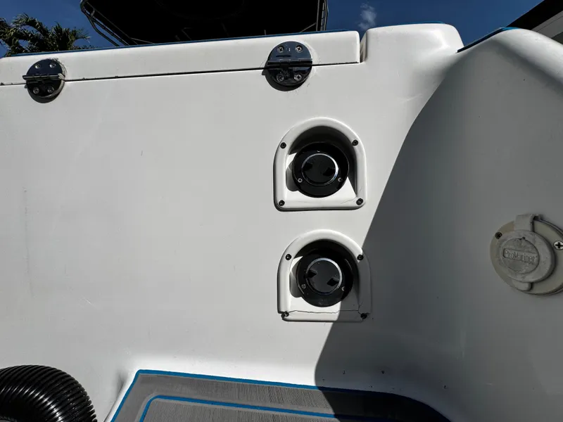 Slide: The Image of 2004 Robalo R 260 boat deck with dual speakers and storage compartment. - 32