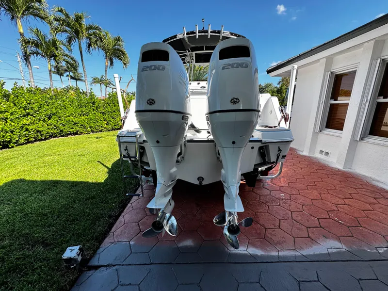 Slide: The Image of 2004 Robalo R 260 boat with twin outboard engines on a sunny driveway. - 5