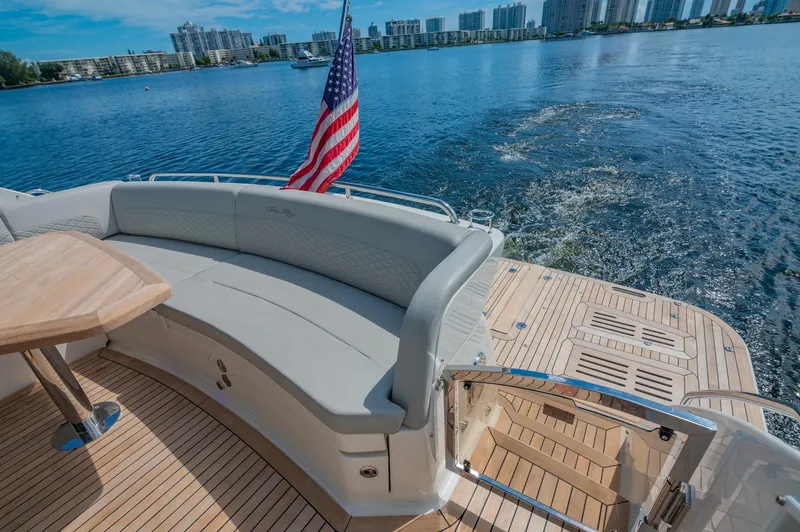 Slide: The Image of 2018 Sea Ray L590 yacht with rear seating and American flag on a sunny day. - 15