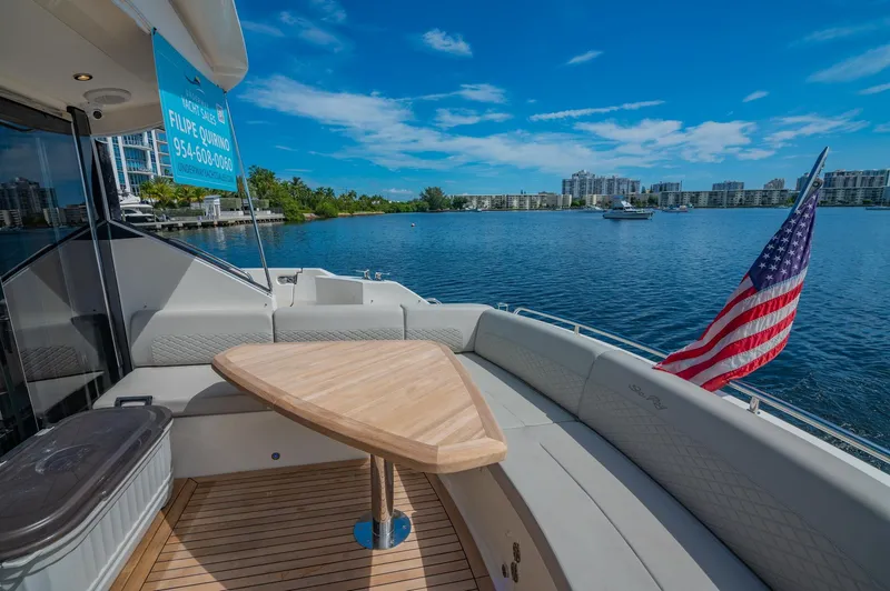 Slide: The Image of 2018 Sea Ray L590 yacht with a scenic waterfront view and American flag. - 18