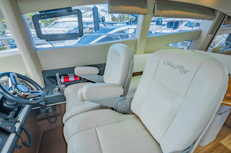 Slide: The Image of 2018 Sea Ray L590 yacht cockpit with leather seats and control panel. - 29