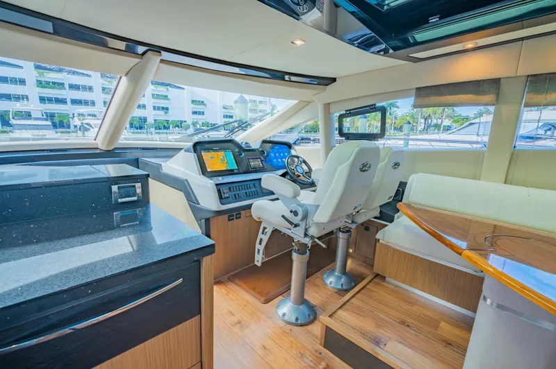 Slide: The Image of 2018 Sea Ray L590 yacht interior with modern helm and seating area. - 32