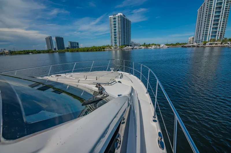 Slide: The Image of 2018 Sea Ray L590 yacht cruising near modern waterfront buildings. - 6