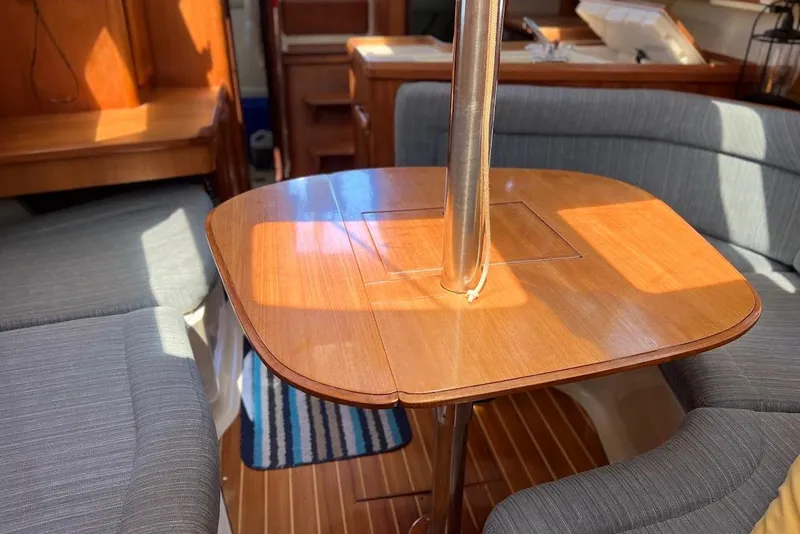 Slide: The Image of Cozy interior of 1995 Hunter 336 sailboat with wooden table and cushioned seating. - 12