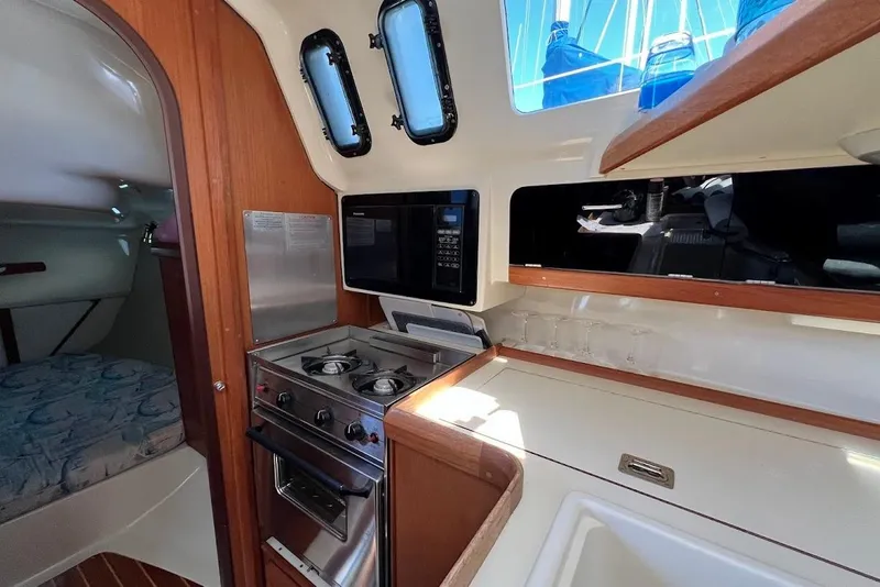 Slide: The Image of 1995 Hunter 336 yacht interior with kitchen, stove, and cozy cabin space. - 14