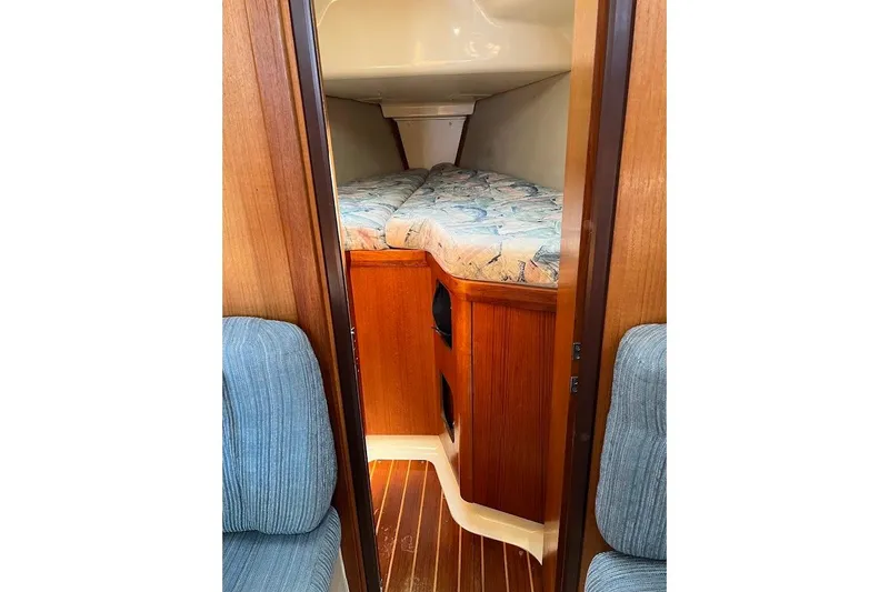 Slide: The Image of Cozy cabin interior of 1995 Hunter 336 sailboat with wooden finish and patterned bedding. - 18
