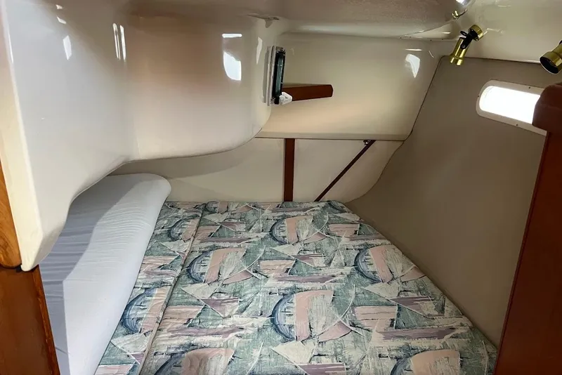 Slide: The Image of Cozy cabin interior of 1995 Hunter 336 sailboat with patterned bedding and porthole. - 21