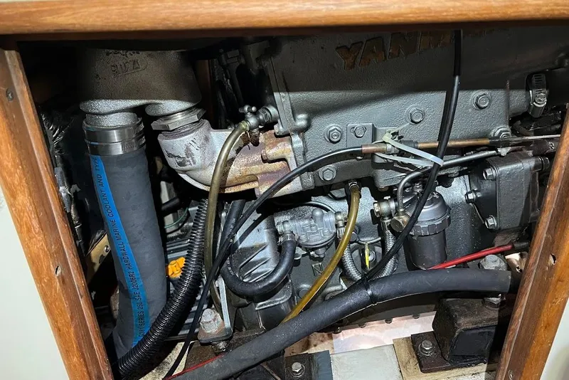 Slide: The Image of Engine compartment of a 1995 Hunter 336 sailboat, featuring Yanmar components and hoses. - 27
