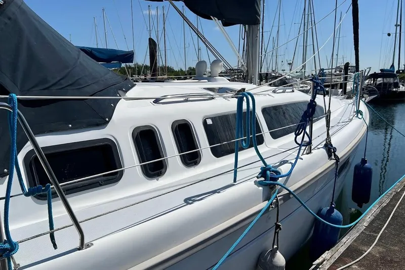 Slide: The Image of Sailboat Hunter 336, 1995 model, docked in marina with blue ropes and fenders. - 5