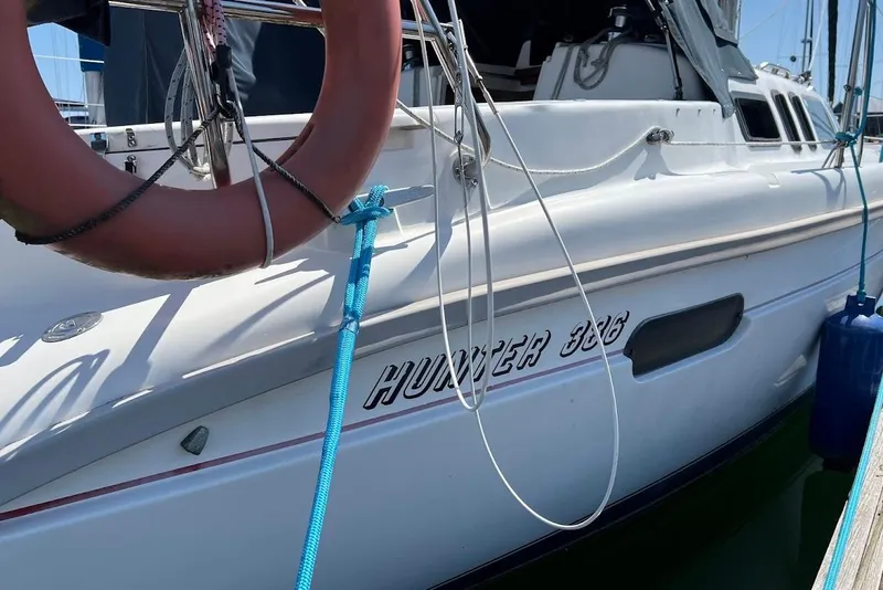 Slide: The Image of 1995 Hunter 336 sailboat docked with visible lifebuoy and blue rope. - 8
