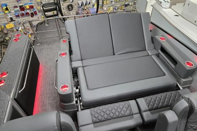 Slide: The Image of 2026 AquaPatio 235 DFL boat interior with gray seating and red cup holders. - 13
