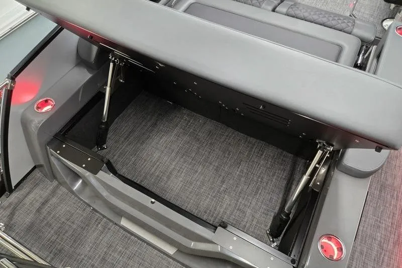 Slide: The Image of 2026 AquaPatio 235 DFL boat interior with open storage compartment and modern seating. - 14