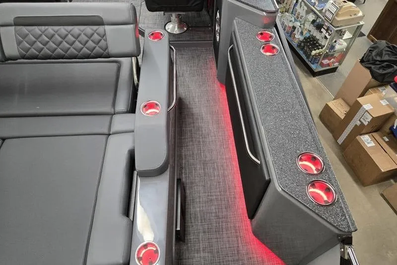 Slide: The Image of 2026 AquaPatio 235 DFL interior with gray seating, red cup holders, and ambient lighting. - 3