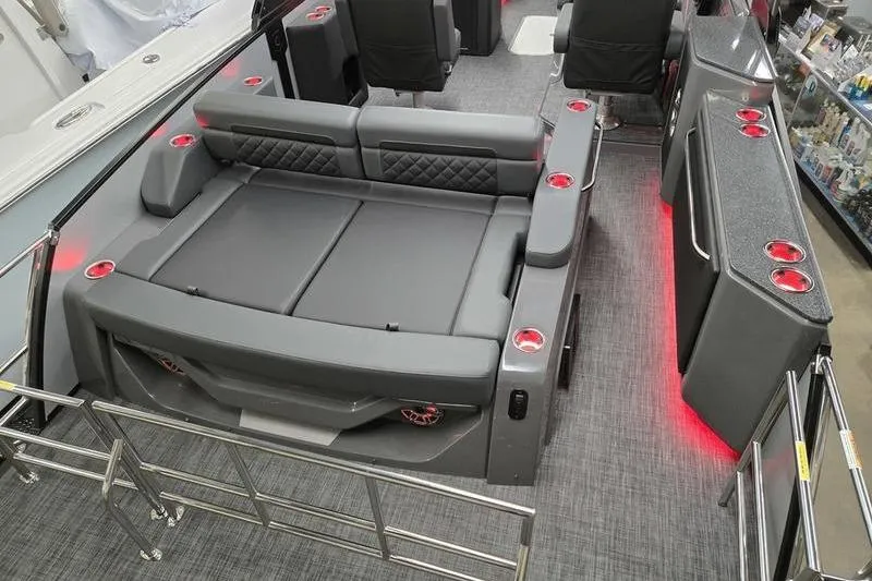 Slide: The Image of 2026 AquaPatio 235 DFL boat interior with gray seating, red lighting, and cup holders. - 4