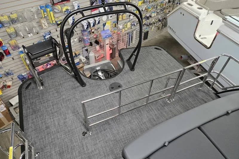Slide: The Image of 2026 AquaPatio 235 DFL boat deck with railing, in a showroom setting. - 6