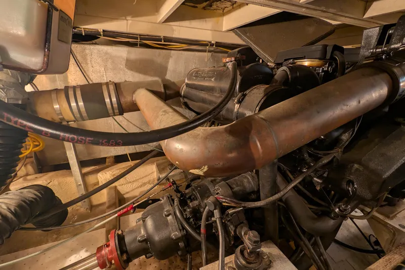Slide: The Image of Engine room of 1984 Chris-Craft 382 Commander with visible pipes and mechanical components. - 111