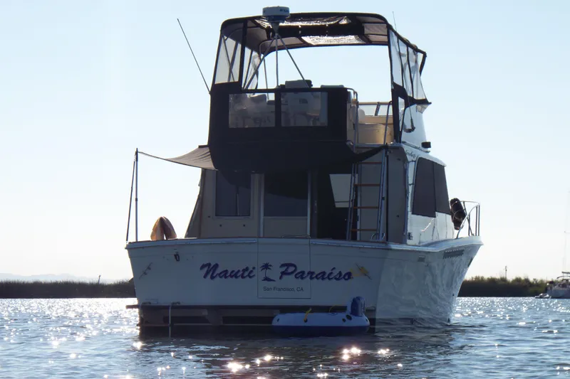 Slide: The Image of 1984 Chris-Craft 382 Commander boat on water, rear view, named "Nauti Paraíso." - 112
