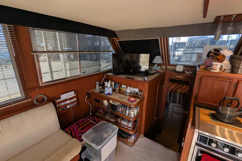 Slide: The Image of Interior of 1984 Chris-Craft 382 Commander yacht with cozy living area and kitchen amenities. - 32