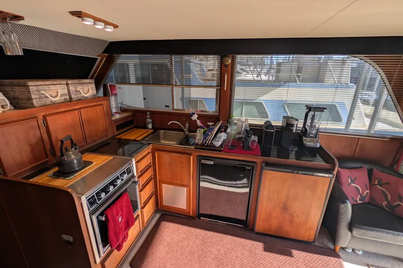 Slide: The Image of 1984 Chris-Craft 382 Commander yacht interior with kitchen, wooden cabinets, and modern appliances. - 34