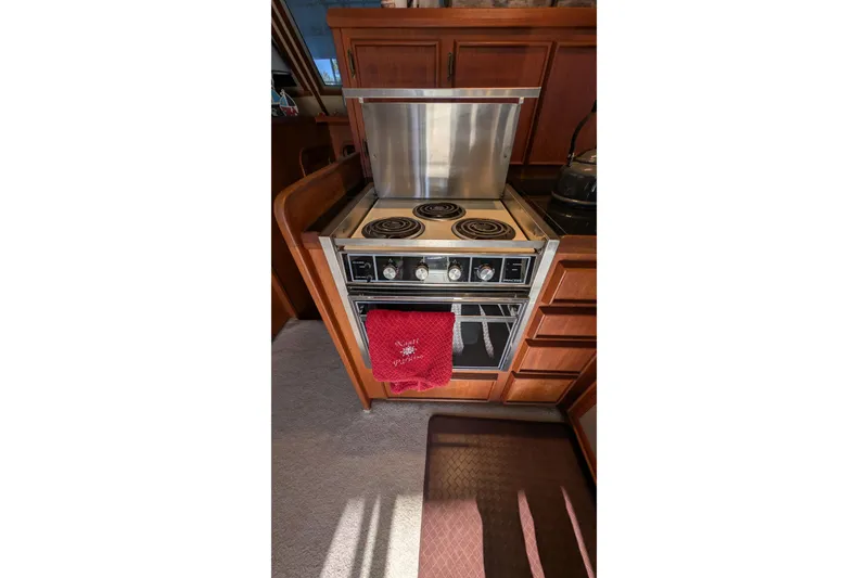 Slide: The Image of 1984 Chris-Craft 382 Commander kitchen with stove and oven, featuring wooden cabinetry. - 41